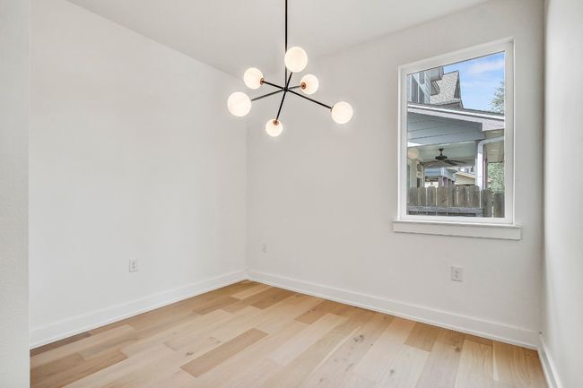 Unfurnished room with baseboards, wood finished floors, and a chandelier | Image 13