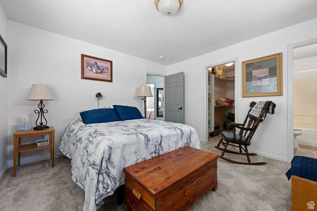 Bedroom featuring light colored carpet, a spacious closet, baseboards, and a closet | Image 13