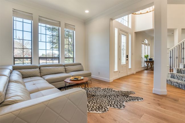 Living room with light wood finished floors, baseboards, stairs, ornamental molding, and recessed lighting | Image 14