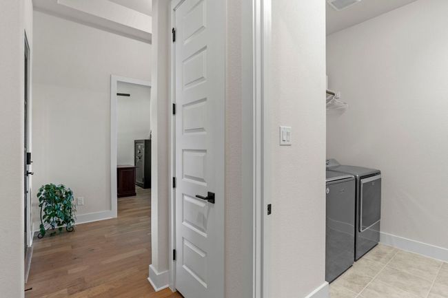 Clothes washing area with baseboards, laundry area, light wood-style flooring, and washer and dryer | Image 6