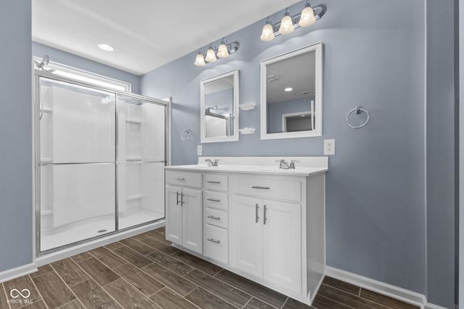 Master bathroom with double vanity, wood tiled floors, and a stall shower | Image 18