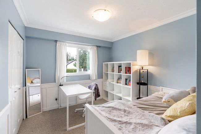 Carpeted bedroom with wainscoting, crown molding, a decorative wall, and a closet | Image 20