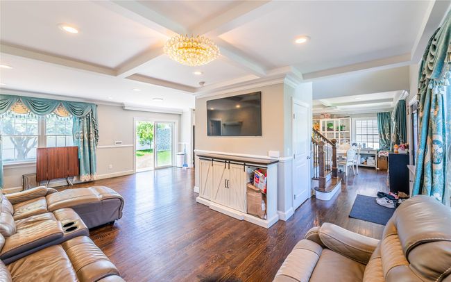 Living area with a chandelier, dark wood-type flooring, recessed lighting, beamed ceiling, and coffered ceiling | Image 27