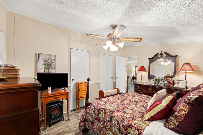 Bedroom featuring wood finished floors, a textured ceiling, and ceiling fan | Image 5