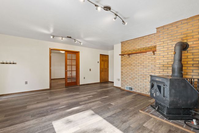 Lower level second living space with walkout to patio & wood stove | Image 36
