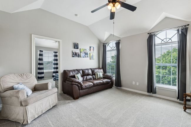 Carpeted living area with ceiling fan, baseboards, and lofted ceiling | Image 22