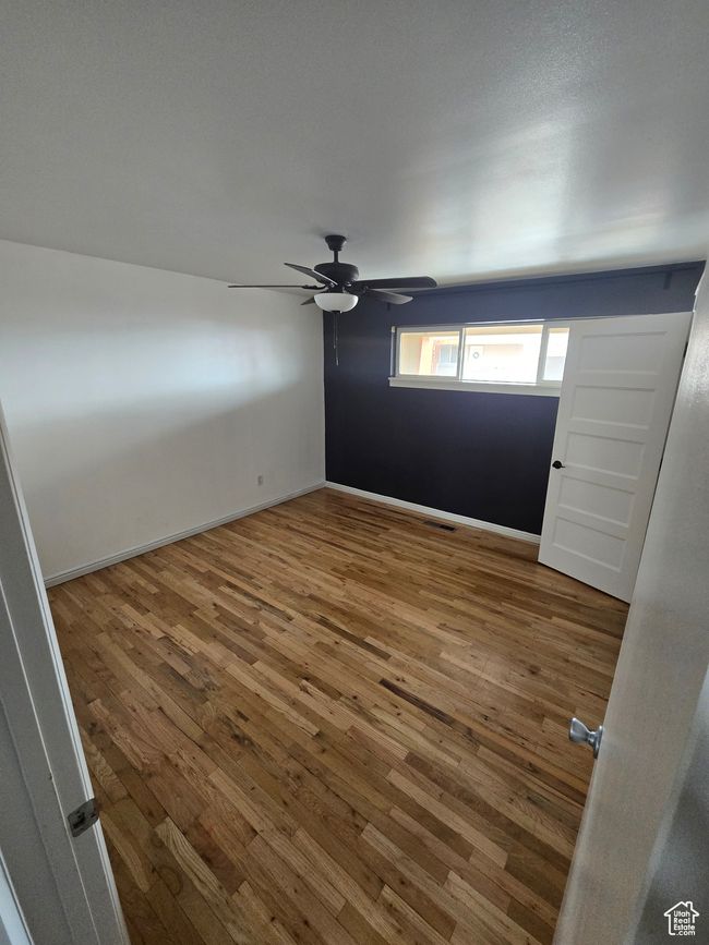 Spare room with wood-type flooring and a ceiling fan | Image 8