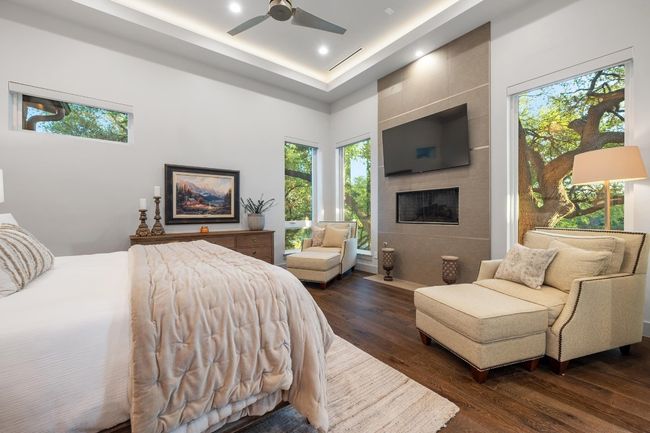 Primary Bedroom with recessed lighting, a tile fireplace, dark wood-style floors, and multiple windows | Image 15