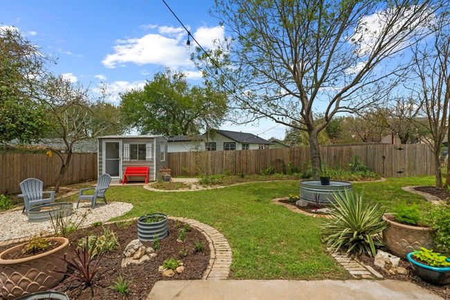 A spacious, fully fenced yard with a fire pit, water feature, & an air conditioned studio! | Image 4
