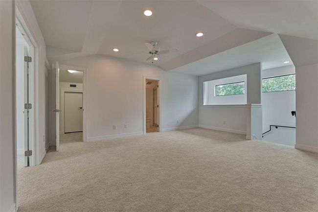 From another angle, the bonus space reveals a thoughtfully designed wall cut-out that allows natural light to flow in, creating a bright and inviting atmosphere. Just beyond, you'll find a full bath and closet, enhancing the functionality and comfort of this private upstairs retreat. | Image 34