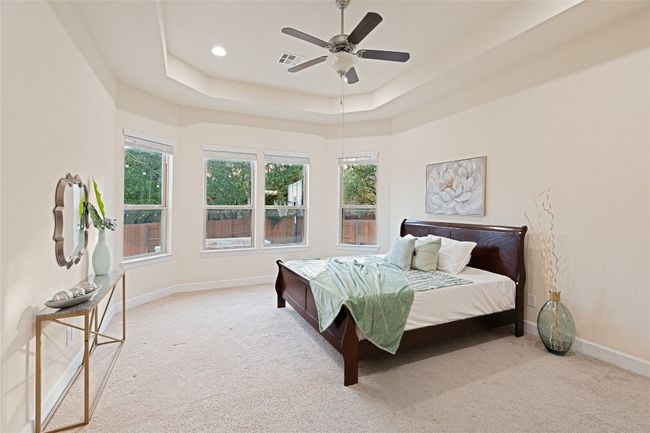 Carpeted bedroom with a tray ceiling and ceiling fan | Image 18
