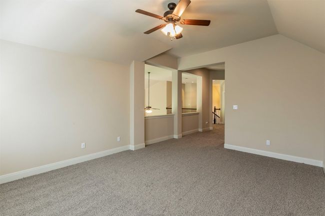 Bonus room with vaulted ceiling, carpet floors, baseboards, and ceiling fan | Image 32