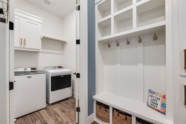 Laundry area featuring washing machine and clothes dryer, light wood finished floors, and cabinet space | Image 18