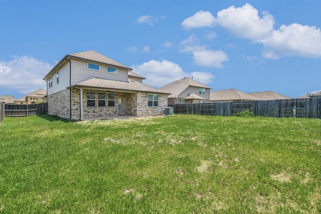 Back of property with a patio, brick siding, central AC unit, and a shingled roof | Image 31