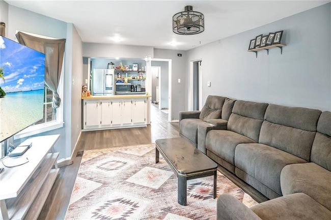 Living room featuring light wood-style floors and baseboards | Image 4