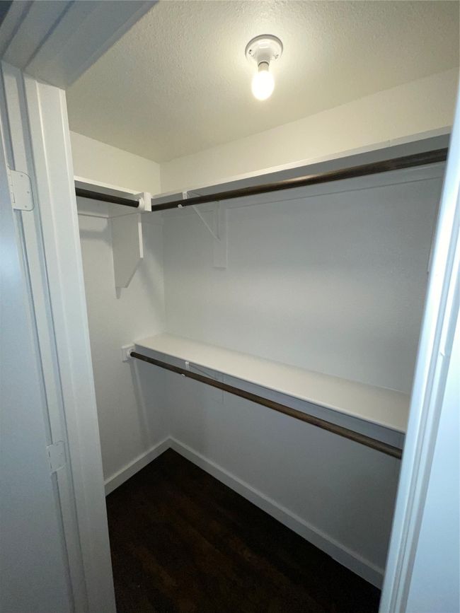 Walk in closet with dark wood-style flooring | Image 11