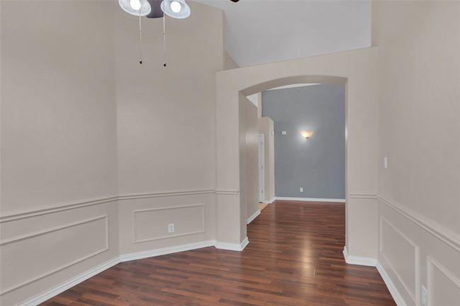 Hall featuring arched walkways, wood finished floors, a decorative wall, and wainscoting | Image 32