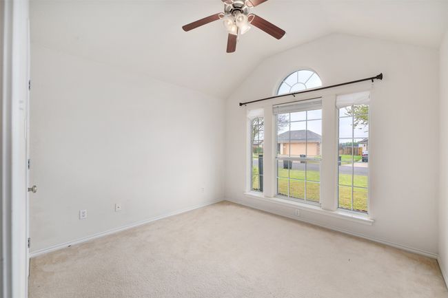 Carpeted bedroom with baseboards, lofted ceiling, and ceiling fan | Image 14
