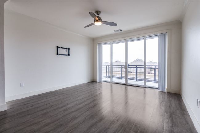 Empty room with a ceiling fan and dark wood-type flooring | Image 16