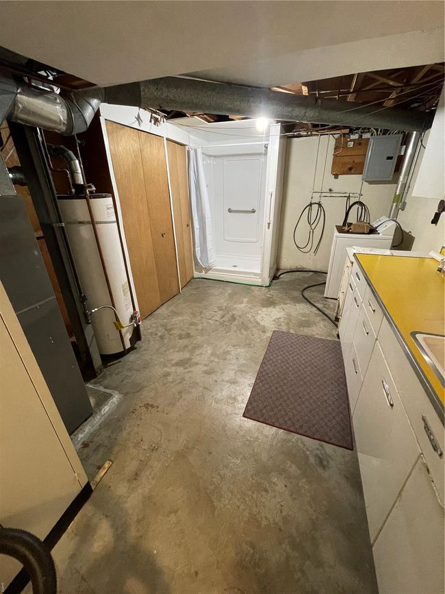Unfinished basement with electric panel, water heater, and washer / clothes dryer | Image 37