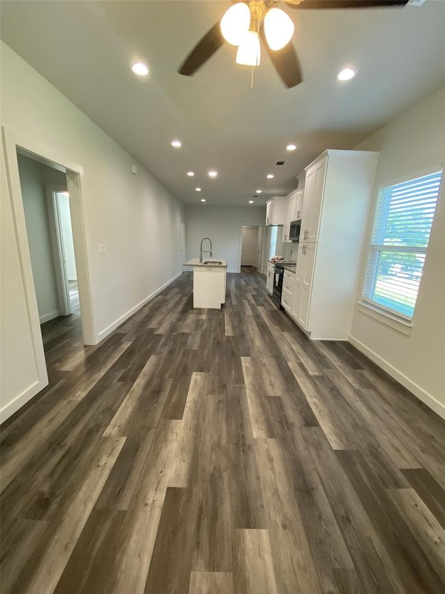 Unfurnished living room featuring ceiling fan, dark wood-style floors, recessed lighting, and baseboards | Image 5