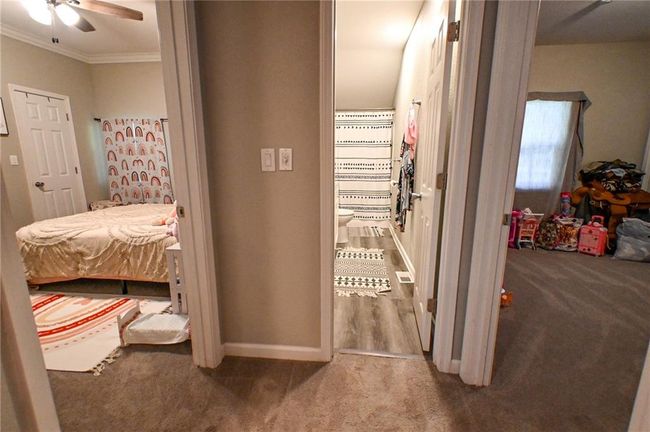 Hallway featuring carpet flooring, crown molding, and baseboards | Image 32