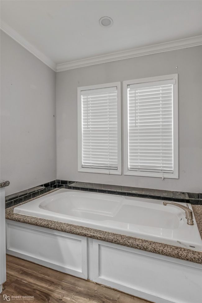 Full bath featuring crown molding, a bath, and wood finished floors | Image 28