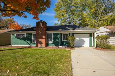 Ranch-style home featuring a front lawn and a garage | Image 1