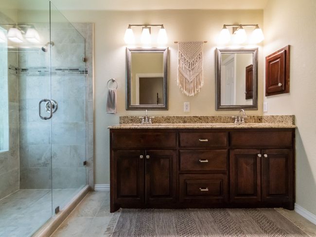 Updated Primary Bathroom with frameless glass door, designer tile, double sinks, updated lighting, medicine cabinet, and framed mirrors. | Image 22