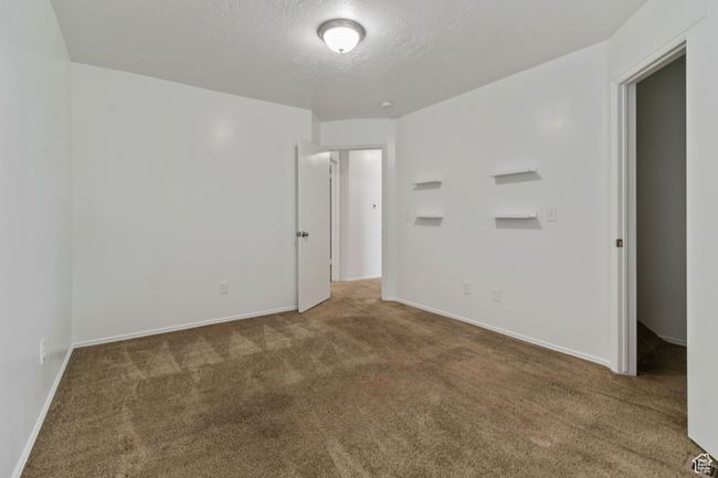 Empty room with carpet and a textured ceiling | Image 13