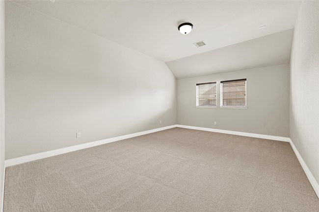 A soft-hued bedroom upstairs with gently sloped ceilings and generous windows feels cozy and elevated. | Image 32
