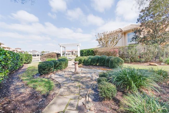 Open space behind rear of home with walkway, pergola and waterfront green space. | Image 42