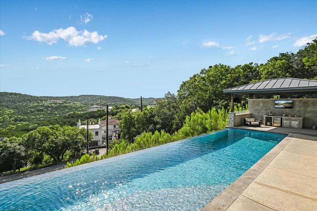 View of pool with a gazebo, an infinity pool, a mountain view, an outdoor kitchen, and a patio | Image 36