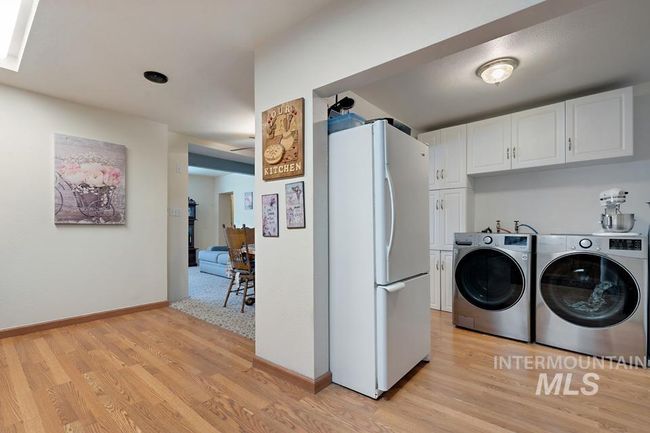 Laundry area featuring washing machine and dryer and light wood-style floors | Image 14