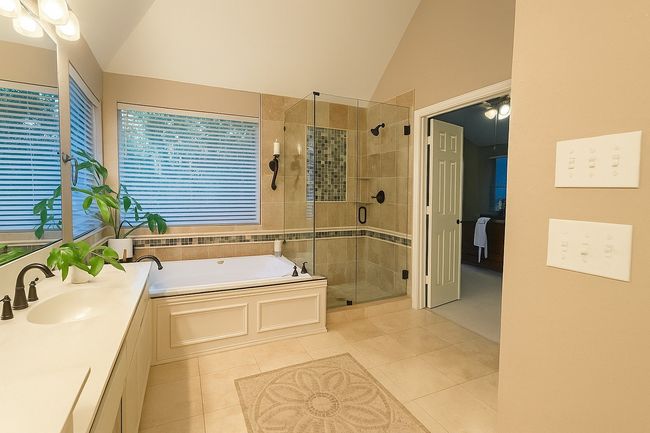 Bathroom with tile patterned flooring, vaulted ceiling, a stall shower, a bath, and vanity | Image 31