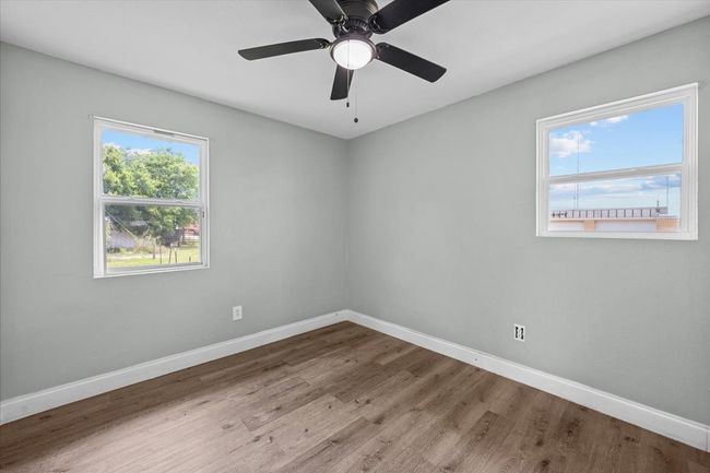 Unfurnished room featuring baseboards, wood finished floors, and a ceiling fan | Image 11