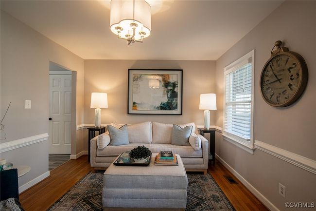 Living room with a chandelier, visible vents, baseboards, and wood finished floors | Image 5