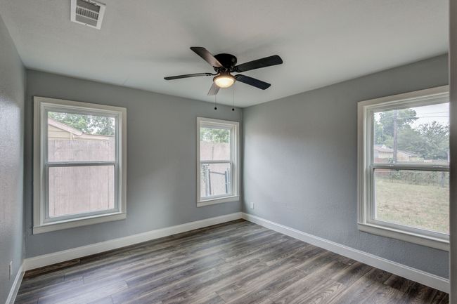 Spare room featuring wood finished floors, baseboards, and a ceiling fan | Image 7