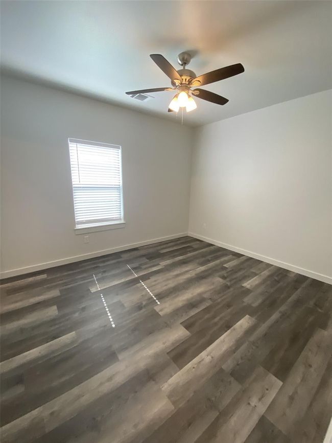 Unfurnished room featuring baseboards, dark wood finished floors, and ceiling fan | Image 9
