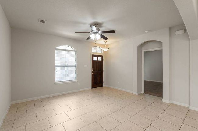 Archway and door to the right leads to the primary bedroom suite. | Image 21