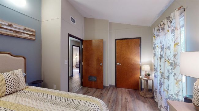 Bedroom with wood finished floors and vaulted ceiling | Image 29