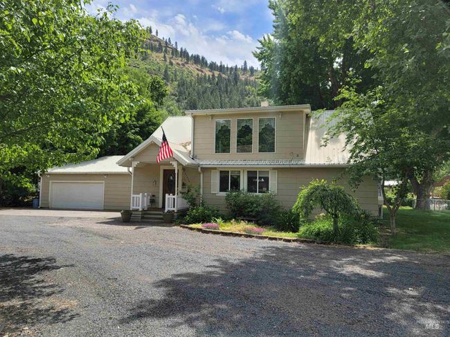 View of front of home with gravel driveway and an attached garage | Image 5