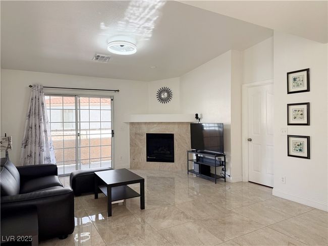Living room with visible vents, a premium fireplace, baseboards, and marble finish floor | Image 10