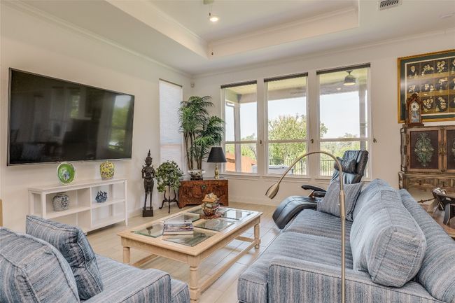 Living room featuring a tray ceiling, crown molding, wood finished floors, and ceiling fan | Image 10