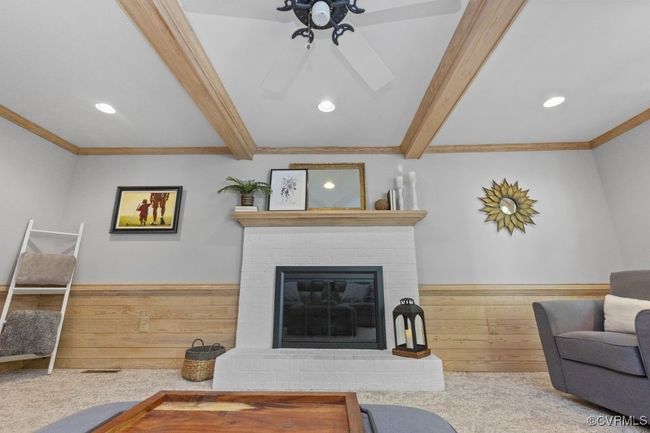 Living room with beam ceiling, ornamental molding, recessed lighting, a fireplace, and a ceiling fan | Image 15