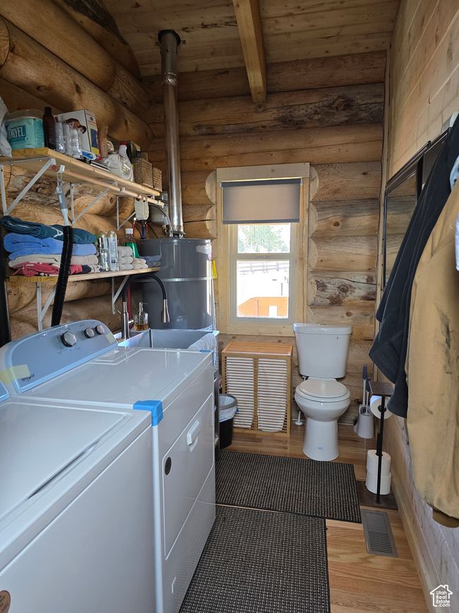 Clothes washing area with visible vents, light wood finished floors, laundry area, washer and clothes dryer, and wood ceiling | Image 114