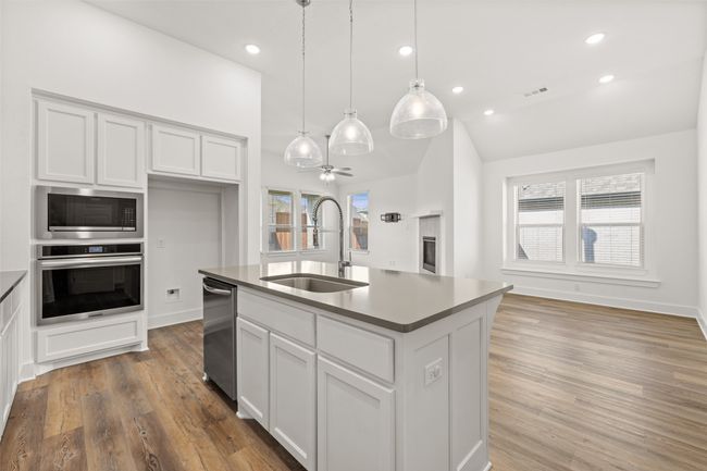 Kitchen featuring white cabinets, a sink, appliances with stainless steel finishes, and visible vents | Image 9