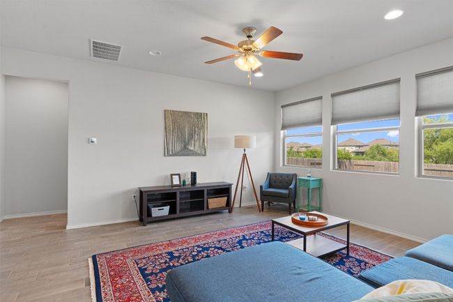The sun-drenched living room features a wall of windows with top up and bottom down shades you can move with the changing of the sunlight. | Image 6