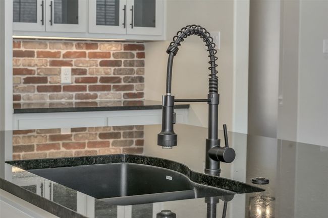 Details featuring a sink, glass insert cabinets, white cabinets, and dark stone counters | Image 13