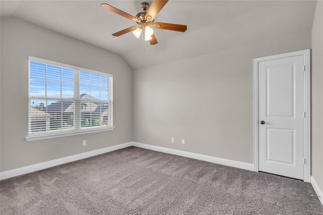 Spare room with lofted ceiling, carpet floors, baseboards, and a ceiling fan | Image 24